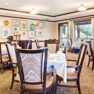 A cozy dining room with elegantly set tables and artistic decor on the walls.
