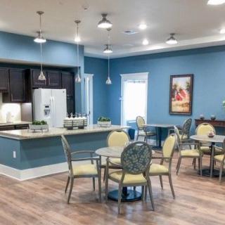A modern kitchen and dining area with blue walls and wooden flooring.
