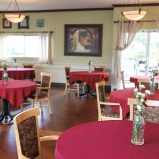 A cozy dining area featuring red tablecloths and artistic wall decor.