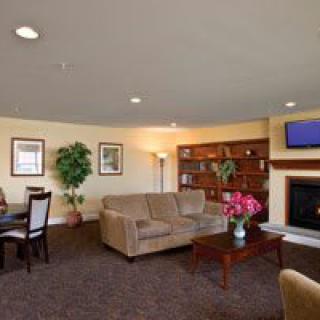 A cozy living room with a sofa, coffee table, television, and bookshelves.