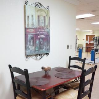 A cozy dining area featuring a wooden table and chairs, complemented by a decorative wall art piece.