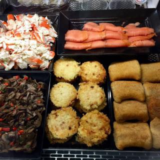 An assortment of buffet items including crab meat, smoked salmon, mushrooms, pastries, and other appetizers.