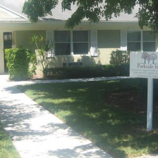 A residential house with a yard and a sign in front.