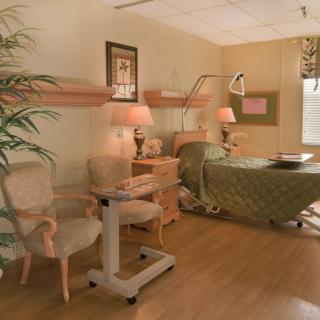 A well-furnished hospital room with a patient bed and medical equipment.