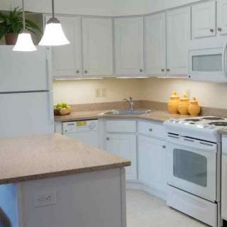 A modern kitchen with white cabinets and appliances.