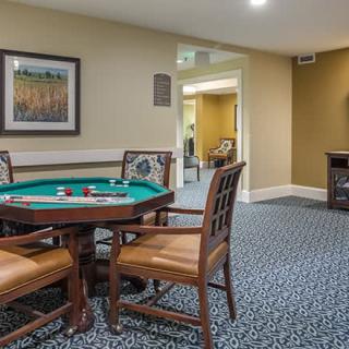 A cozy game room featuring a poker table with chairs and wall artwork.