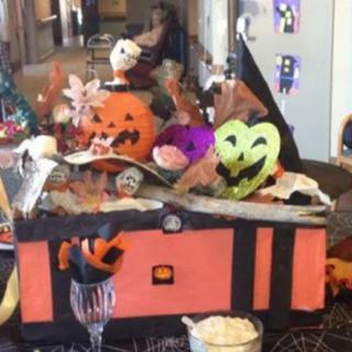 A festive Halloween display featuring pumpkins and colorful masks arranged on a table.