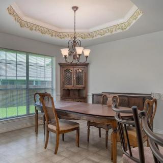 A traditional dining room with a wooden table, chairs, and a chandelier.