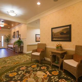A warmly decorated hallway with seating and artwork.