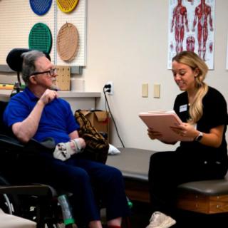 A therapy session in progress with a patient and a therapist discussing treatment plans.