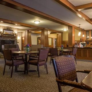 A cozy dining area with tables and chairs, featuring warm lighting and a relaxed ambiance.