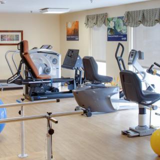 A well-equipped fitness center with various exercise machines and rehabilitation tools.