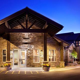 A warmly lit building entrance with a stone facade, captured at night.