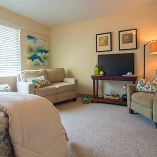 A cozy living room with a sofa, TV, and ambient lighting.