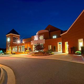 A well-lit modern building at night with distinctive architectural features.