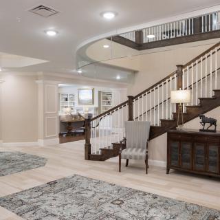 A spacious and elegantly designed interior featuring a modern staircase and comfortable seating.