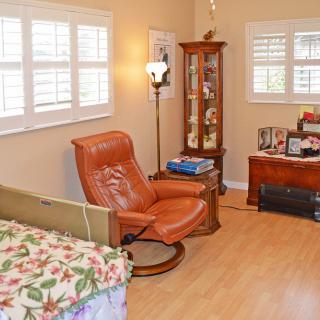 Cozy living room with a leather chair, wooden cabinet, and natural lighting.