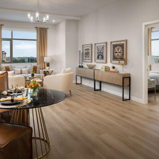 A modern open-space living and dining area with elegant decor and wooden flooring.