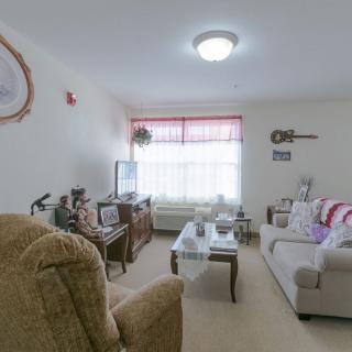 A cozy living room featuring a couch, television, and wall decorations.
