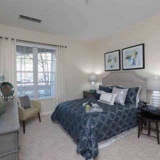 A cozy bedroom with elegant decor and a large window.