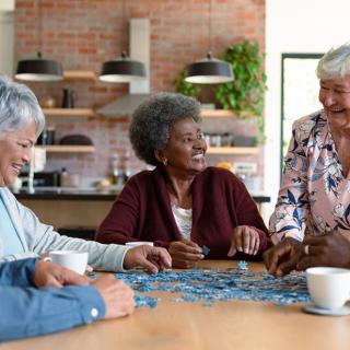 A group of seniors enjoying a puzzle together at home.
