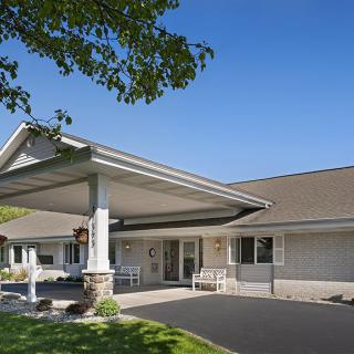 A well-maintained building entrance with a covered driveway.