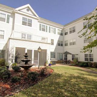 A residential building with a landscaped garden and fountain.