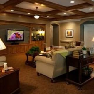 A cozy living room with comfortable furniture, a TV, and warm lighting.