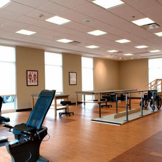 A well-lit rehabilitation space equipped with exercise equipment and a welcoming atmosphere.
