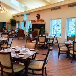 A spacious dining area with neatly arranged tables and chairs, featuring natural lighting and elegant decor.