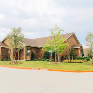 A charming brick house surrounded by well-maintained landscaping.