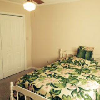A cozy bedroom with floral bedding and simple decor.