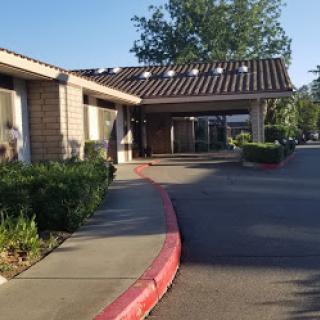 A view of a welcoming building with a tiled roof and landscaped surroundings.