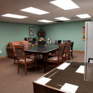 A well-lit conference room with a large table and several chairs, suitable for meetings.