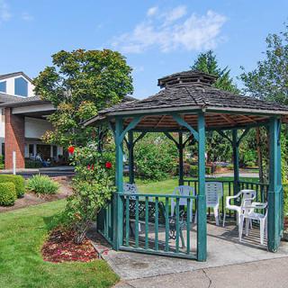 A scenic view of a gazebo surrounded by lush greenery in a garden setting.