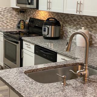 A modern kitchen with granite countertops and various appliances.