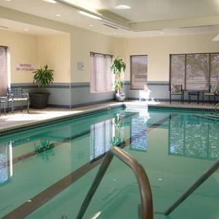 An inviting indoor swimming pool area in a hotel with natural light and seating.
