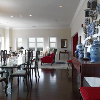 A spacious dining room with elegant furniture and decorative blue vases adorning the walls.