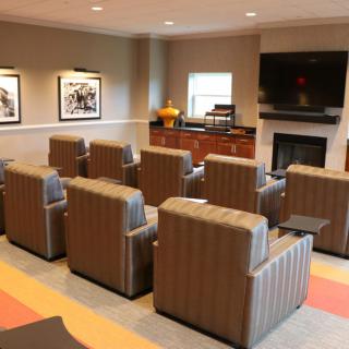 A cozy lounge area with multiple comfortable chairs facing a television.