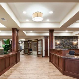 A spacious lobby area with a wooden reception desk and modern lighting.