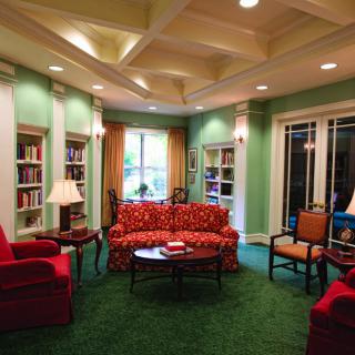 A cozy library living room with colorful furniture and bookshelves.