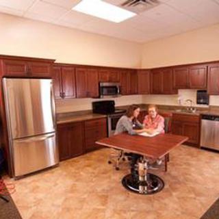 Two people sitting at a table in a modern kitchen.