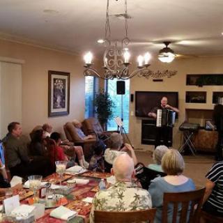 A lively gathering where guests enjoy music played on an accordion.
