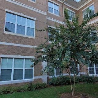 A view of an apartment building with landscaped surroundings.