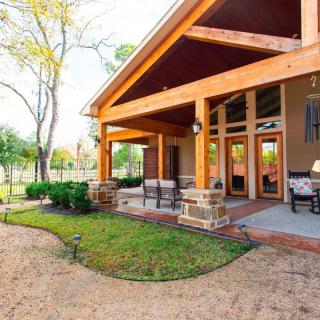 A cozy backyard patio with comfortable seating and wooden architecture.