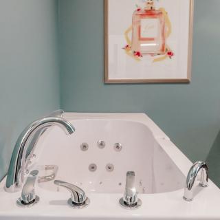 A modern bathroom with a sleek bathtub and wall art.