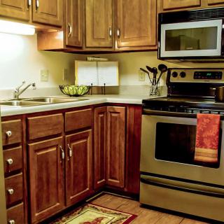 A cozy kitchen with wooden cabinets, stainless steel appliances, and a warm ambiance.