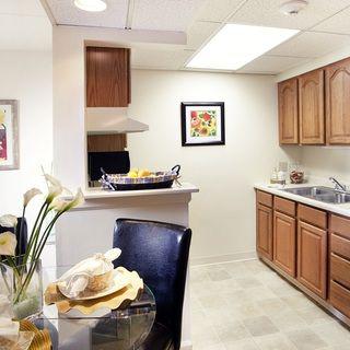 A modern kitchen with wooden cabinets and a small dining area.