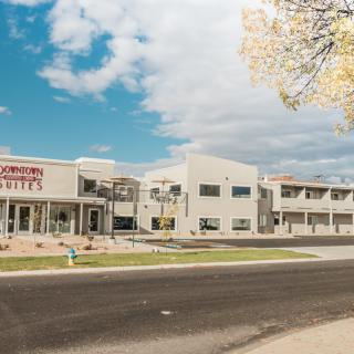 Modern hotel exterior with clear blue skies and a road in the foreground.