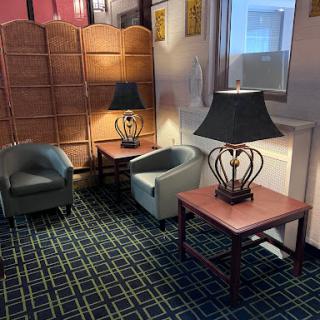 A cozy corner in a lobby featuring comfortable chairs, stylish lamps, and elegant tables.